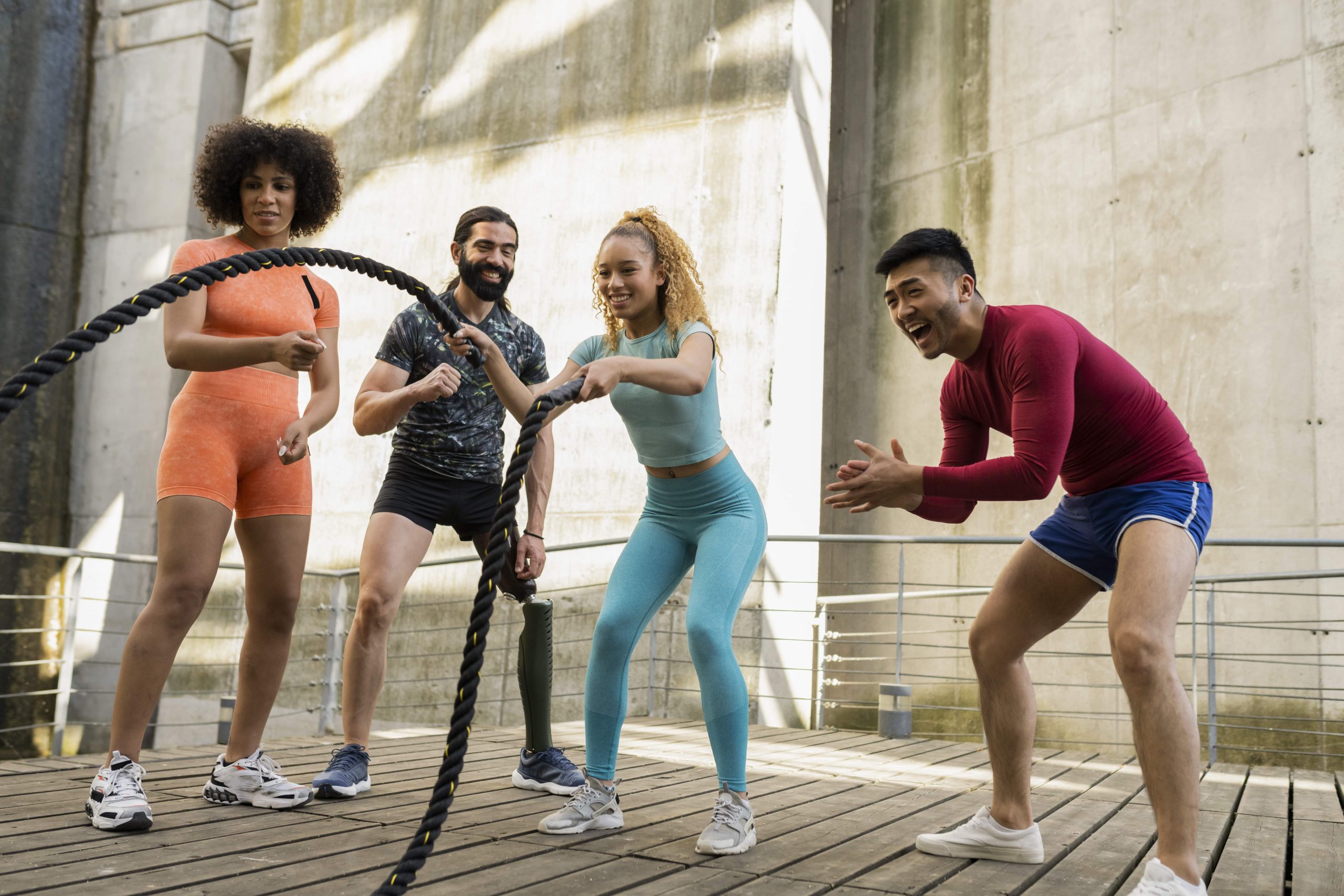 Personas entrenando en grupo con cuerdas de batalla durante una sesión de fitness al aire libre.